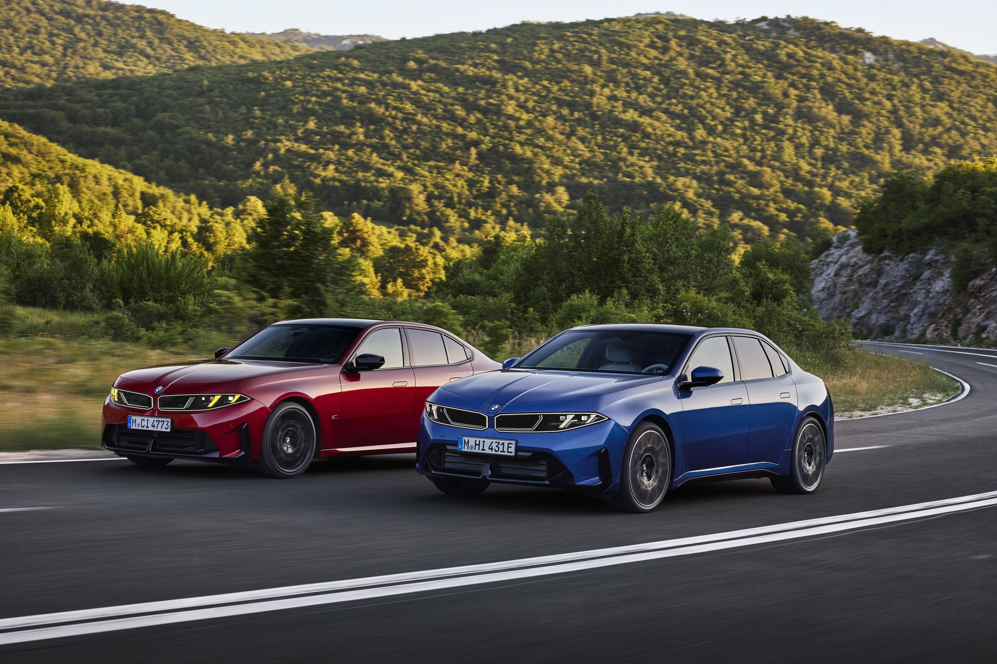 Dos unidades del nuevo BMW Serie 3, una roja y otra azul, circulando por una carretera de montaña